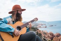 Mann spielt Gitarre an der Küste — Stockfoto