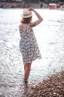 Mulher em pé na água na praia — Fotografia de Stock