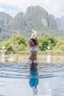 Femme en bikini assis au bord de la piscine — Photo de stock