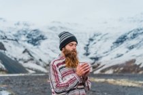 Uomo che tiene la tazza in piedi nella natura — Foto stock