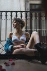 Femme en lingerie et bottes assis sur le balcon — Photo de stock