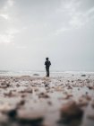 Turista masculino de pie en el océano tranquilo - foto de stock