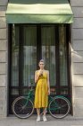 Frau steht mit Oldtimer-Fahrrad auf Straße — Stockfoto