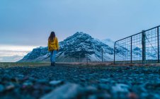 Frau auf Straße in Richtung verschneiter Berg — Stockfoto