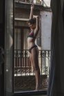 Mulher rindo em lingerie de pé na varanda — Fotografia de Stock