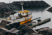 Вітрильник на гранжевому пірсі в темному порту — стокове фото