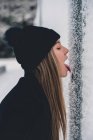 Woman licking frozen pole — Stock Photo