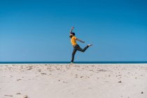 Homem pulando na praia arenosa — Fotografia de Stock