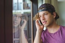 Людина розмовляє на мобільному телефоні у вікні — стокове фото