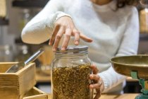Woman opening jar with spice — Stock Photo