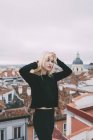 Блондинка стоит на крыше — стоковое фото