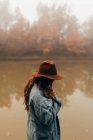 Frau mit Hut steht am Teich — Stockfoto