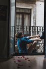 Женщина надевает сапоги на балкон — стоковое фото