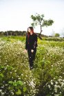 Женщина, стоящая в зеленом поле — стоковое фото
