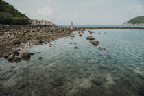 Donna in piedi sulla riva rocciosa a oceano — Foto stock