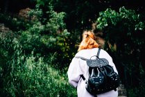 Woman with backpack walking in forest — Stock Photo