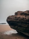 Большой камень на песчаном побережье — стоковое фото