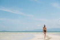 Woman walking on sandy coast — Stock Photo
