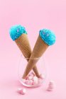 Crème glacée lumineuse de couleur bleue servie dans un cône de gaufre avec guimauve en verre. — Photo de stock