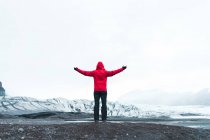 Homem em roupas quentes em pé na paisagem nevada — Fotografia de Stock