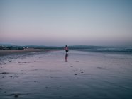 Жінка йде на піщаному пляжі — стокове фото