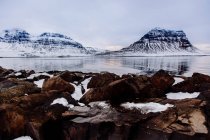 Озеро зі скелями і засніженими горами — стокове фото