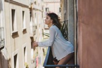 Slim woman standing on balcony — Stock Photo