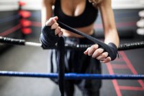 Fitness woman in sport clothes coiling boxing bandage — Stock Photo