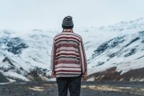 Человек, стоящий в снежных горах — стоковое фото