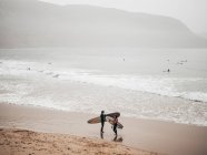 Two surfers with boards on coast — Stock Photo
