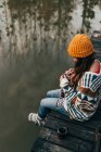 Frau sitzt und strickt am Teich — Stockfoto