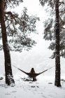 Зимой женщина сидит в гамаке — стоковое фото