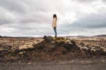 Donna in piedi sulla roccia — Foto stock
