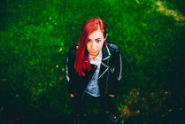 Frau mit rot gefärbten Haaren steht auf Gras — Stockfoto