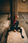 Trendfrau sitzt auf alter Empore — Stockfoto