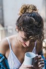 Жінка сміється з чашкою кави на балконі — стокове фото