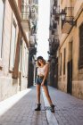 Donna in piedi sulla strada con la gamba in su — Foto stock