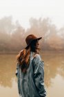 Женщина в шляпе, стоящая у пруда — стоковое фото
