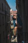 Жінка сидить на балконних перилах — стокове фото