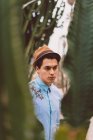 Hombre con sombrero de pie en cactus - foto de stock