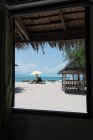 Fenêtre sur la plage de sable avec chaises longues — Photo de stock