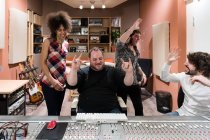Музыканты празднуют успех в студии звукозаписи — стоковое фото