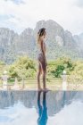 Donna in bikini in piedi a bordo piscina — Foto stock