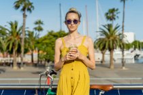 Жінка в літньому одязі стоїть з велосипедом — стокове фото