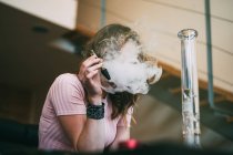 Woman smoking marijuana in a glass blunt — Stock Photo