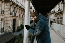Чоловік використовує смартфон на старій вулиці міста — стокове фото