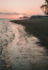 Піщаний пляж на заході сонця — стокове фото