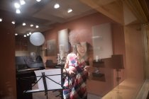 Vocalista femenina cantando en estudio - foto de stock