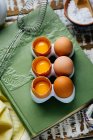 Huevos enteros y agrietados en libro - foto de stock