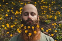 Hombre con flores en barba - foto de stock